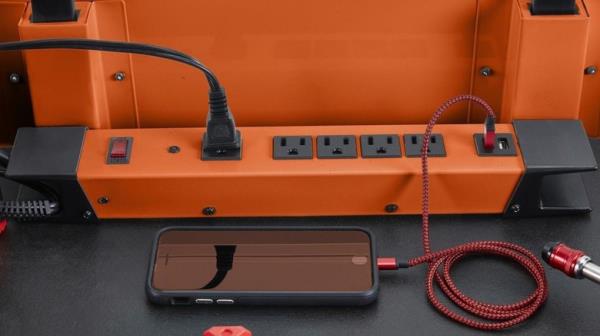 Phone plugged into an orange power strip 